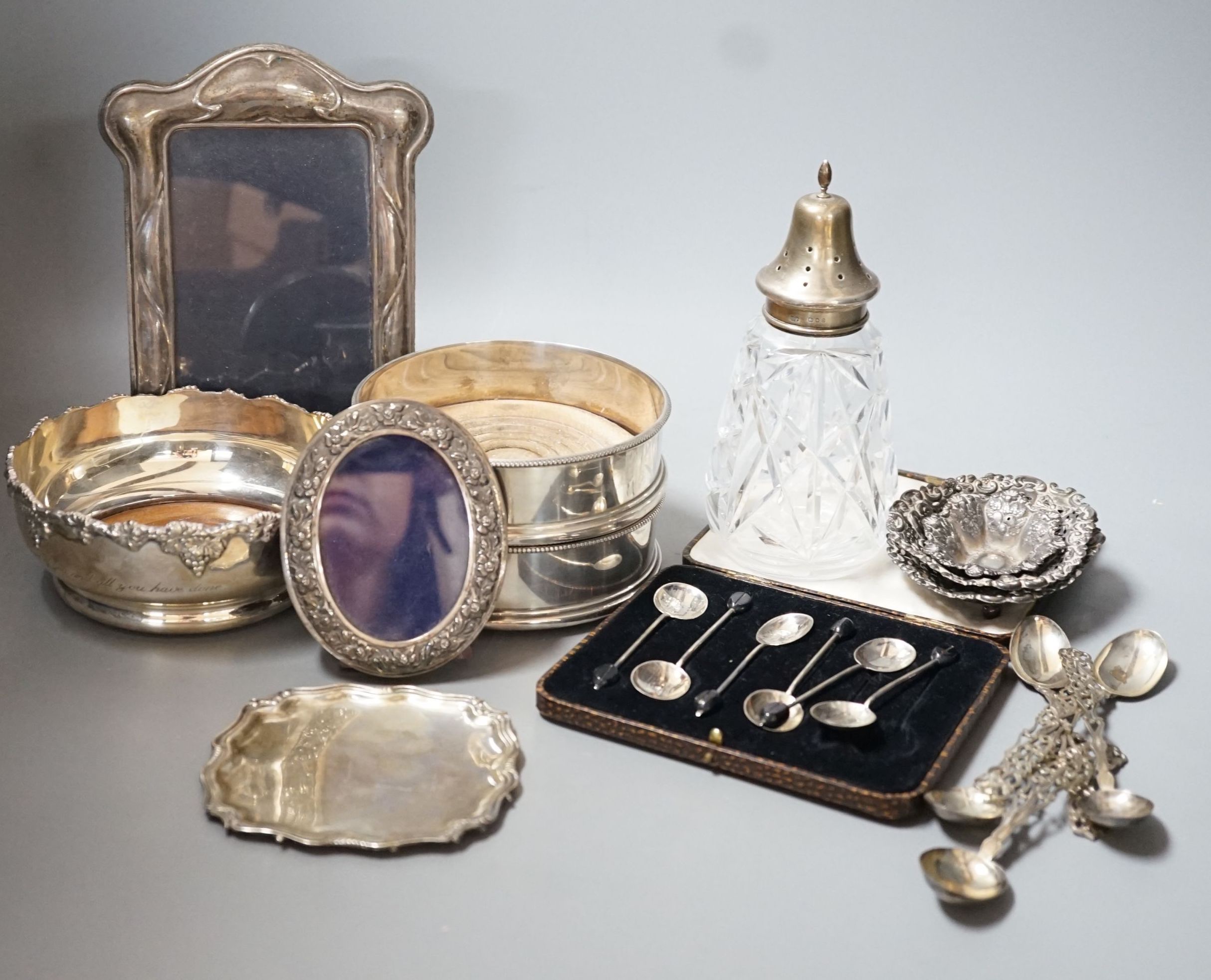 Mixed small silver including a pair of modern silver mounted wine coasters, 12.6cm, two silver mounted photograph frames, silver dish by William Comyns, three silver bonbon dishes, two sets of six silver teaspoons, a sil
